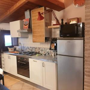 uma cozinha com um frigorífico de aço inoxidável e um micro-ondas em Nuovo interno Nuova atmosfera Stazione Beato Matteo em Vigevano