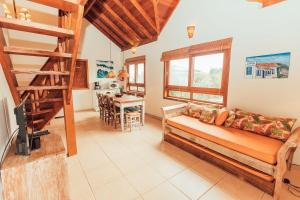 uma sala de estar com um sofá e uma escada de madeira em Acomodações Ibirawave em Barra de Ibiraquera