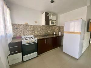 a kitchen with a stove and a white refrigerator at Moderno Departamento en CABA 2 Ambientes con Patio in Buenos Aires