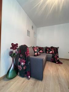 a living room with a couch and a vase with flowers at Zgierz Parzęczewska District in Zgierz