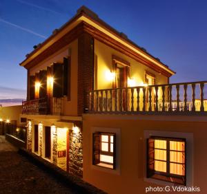 a building with a balcony with lights on it at Yasemi of Chios "Adults Only" in Volissos