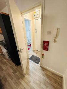 Premium Studio Flat 08 in Central London في لندن: ممر مع باب يؤدي إلى الحمام