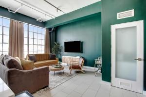a living room with a couch and a television at NYC Styled Loft In DTLA, sleeps 4 with Free Parking! in Los Angeles