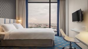 新加坡Holiday Inn Express Singapore Katong by IHG的一间带床和大窗户的酒店房间 更多37张照片