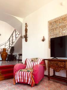 sala de estar con silla y TV en Villa Rosanna en Massa Lubrense