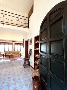 eine große schwarze Tür in einem Zimmer mit Sofa in der Unterkunft Villa Rosanna in Massa Lubrense