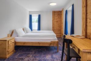 Schlafzimmer mit einem Bett, einem Schreibtisch und einem Schreibtisch in der Unterkunft Kapitel 7 Boutique-Hotel in Raron