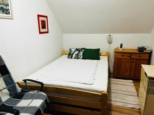 - une petite chambre avec un lit et une chaise dans l'établissement Gabi apartman, à Fonyód
