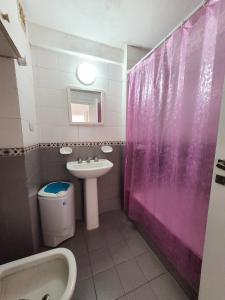 a bathroom with a pink shower curtain and a sink at Playa grande in Mar del Plata
