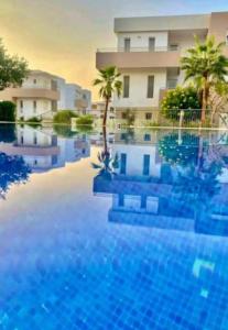 una gran piscina frente a un edificio en Appartement avec piscine taghazout imi Ouaddar en Agadir nʼ Aït Sa