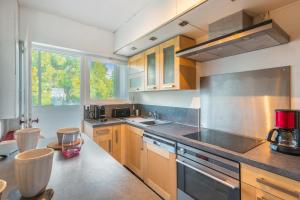 バンドールにあるAppartement l’Eden Azur - Welkeysのキッチン(木製キャビネット、ステンレス製の電化製品付)