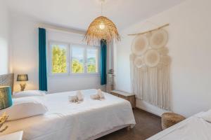 バンドールにあるAppartement l’Eden Azur - Welkeysの白いベッドルーム(ベッド2台、窓付)