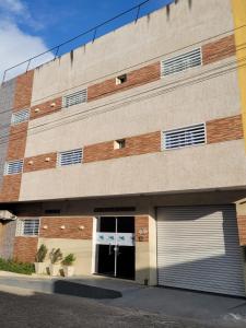 un edificio con dos puertas de garaje delante de él en Pousada Ramon en Remígio