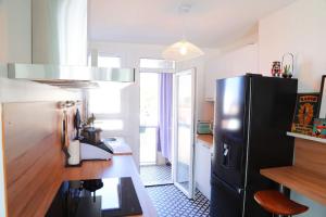eine Küche mit einem schwarzen Kühlschrank und einer Theke in der Unterkunft T3 Lyon 8 parc parilly-Eurexpo -9min en voiture in Vénissieux