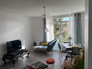 ein Wohnzimmer mit einem Tisch und einem Sofa sowie einem Tisch und Stühlen in der Unterkunft T3 Lyon 8 parc parilly-Eurexpo -9min en voiture in Vénissieux