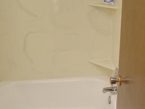 a bathroom with a white tub and a sink at Siesta Motel in Havre