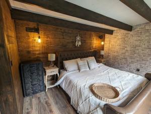 1 dormitorio con 1 cama grande y pared de ladrillo en Gorgeous countryside cabin, en Lyminge