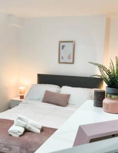 Un dormitorio con una cama blanca y una planta en Newly furnished Apartment, Leicester City Centre, en Leicester
