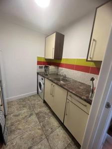 a kitchen with a sink and a washing machine at Newly furnished Apartment, Leicester City Centre in Leicester