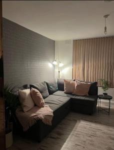 a living room with a couch with pillows on it at Newly furnished Apartment, Leicester City Centre in Leicester