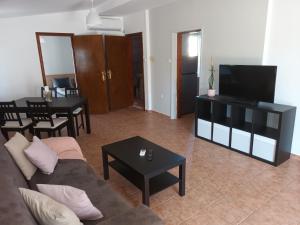 a living room with a couch and a flat screen tv at Peraia Sea view Apartment in Neoi Epivates
