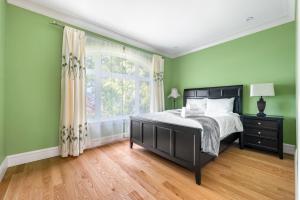 1 dormitorio con paredes verdes, 1 cama y ventana en Vancouver Haven: Luxurious Private Bedroom near Attractions, en Vancouver