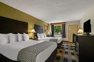 Habitación de hotel con 2 camas y TV de pantalla plana. en Best Western Windsor Suites en Fayetteville