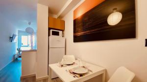 una pequeña cocina con mesa blanca y microondas en Click&Guest - Studio La Lajilla, en Mogán