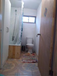 baño con aseo y ducha y ventana en Casa Tricahuelqui, en Horcón