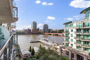 Blick auf einen Fluss mit einer Brücke und Gebäuden in der Unterkunft Vauxhall large 2bedroom Central London with amazing River View Panoramic Balcony in London