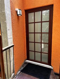 una puerta con una ventana en el lateral de un edificio en Casa Olivo en Ciudad de México