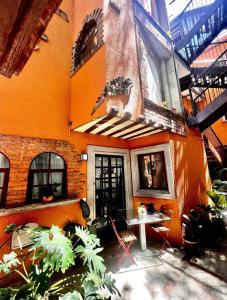 un edificio naranja con una mesa delante en Casa Olivo, en Ciudad de México