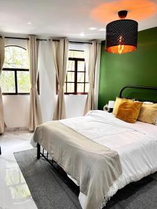 1 dormitorio con 1 cama grande y pared verde en Casa Olivo, en Ciudad de México