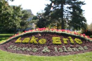 a sign in the grass with flowers in a park at Hampton Inn Sandusky-Central in Sandusky