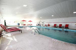 una gran piscina con sillas rojas en un edificio en Hampton Inn Sandusky-Central en Sandusky