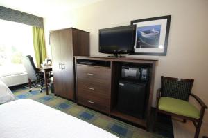 a hotel room with a bed and a flat screen tv at Hampton Inn Sandusky-Central in Sandusky