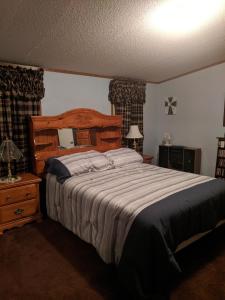 a bedroom with a large bed with a wooden headboard at Thomas Holiday Home in Clearfield