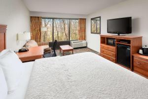 Habitación de hotel con cama y TV de pantalla plana. en Hampton Inn Oak Ridge Knoxville, en Oak Ridge