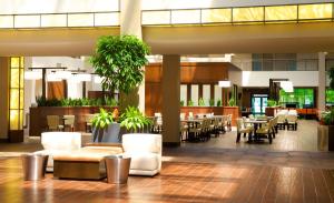 a lobby with tables and chairs and a cafeteria at Embassy Suites by Hilton Cincinnati Northeast - Blue Ash in Blue Ash