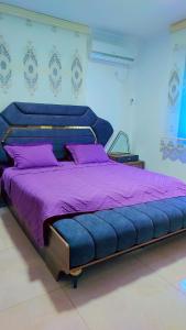 duże niebieskie łóżko z fioletową pościelą w pokoju w obiekcie Rellax Villa w Jerozolimie