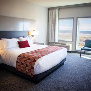 オーシャン・ショアーズにあるQuinault Beach Resort & Casinoの大きなベッドと大きな窓が備わるホテルルームです。