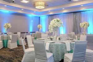a banquet hall with white tables and chairs and flowers at Hilton Garden Inn Shirlington in Arlington