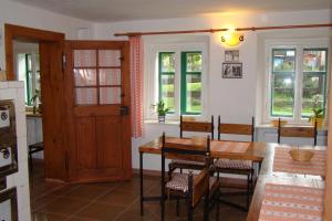 a dining room with a table and chairs and windows at U Jindrů in Abertamy