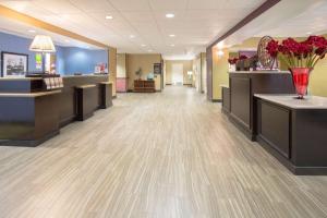 una sala de espera en un salón con un jarrón de flores rojas en Hampton Inn Santa Rosa, en Santa Rosa