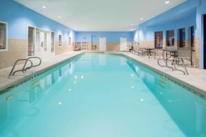 una gran piscina con paredes azules, mesas y sillas en Hampton Inn Santa Rosa, en Santa Rosa