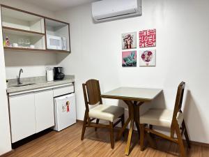 a kitchen with a table and chairs in a room at Belavista Hotel in Itaberaba