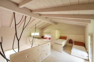 ein kleines Zimmer mit zwei Betten und einer Couch in der Unterkunft Quader Nidi nel Verde Authentic Farm Stay in the Italian Alps in Bienno