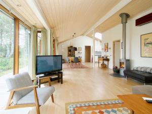 a living room with a flat screen tv and a couch at Three-Bedroom Holiday home in Rørvig 1 in Rørvig