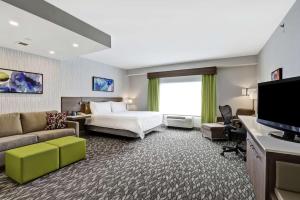 um quarto de hotel com uma cama e um sofá em Hilton Garden Inn Toronto/Ajax em Ajax
