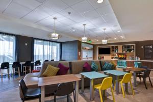 uma sala de espera com mesas e cadeiras e um sofá em Home2 Suites By Hilton Palmdale em Palmdale